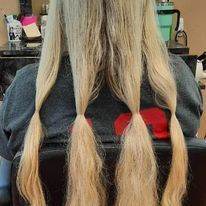 a woman with long blonde hair is sitting in a chair.