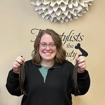 a woman is holding two pieces of hair in her hands.