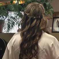 a woman with long hair is getting her hair done in a salon.