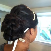 a woman is wearing her hair in a bun with a ribbon around her neck.