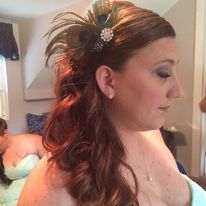 a woman is wearing a peacock feather headband in her hair.