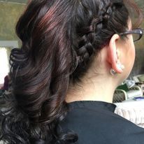 the back of a woman wearing glasses and a braided ponytail.
