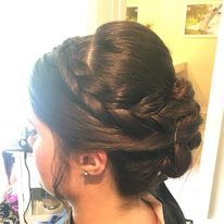a woman is wearing her hair in a braided bun.