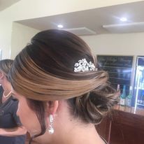 a woman is wearing a bun with a comb in her hair.