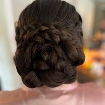a woman is wearing her hair in a braided bun.