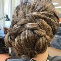 a woman is wearing her hair in a braided bun.