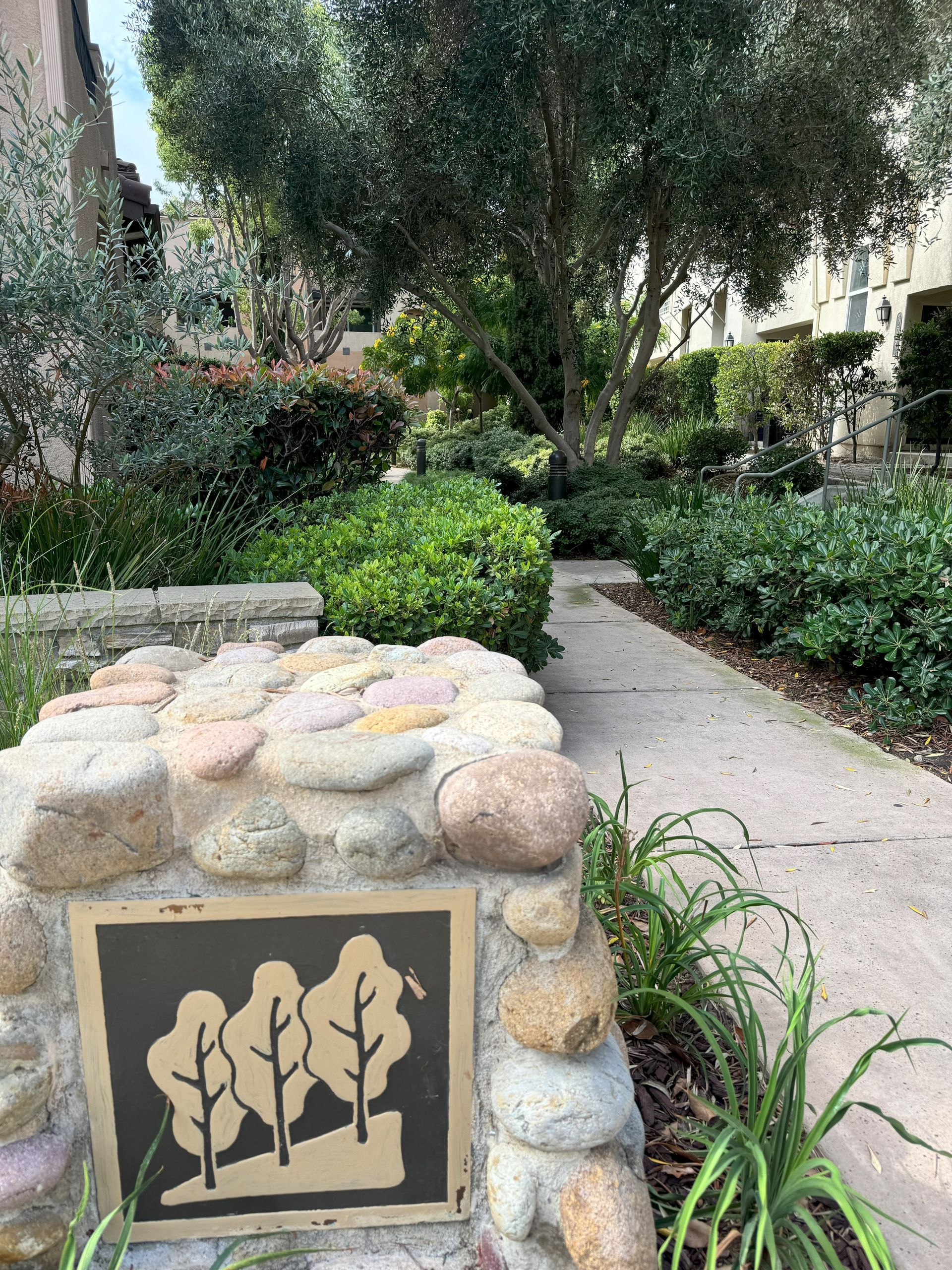 A stone wall with a sign on it in a park