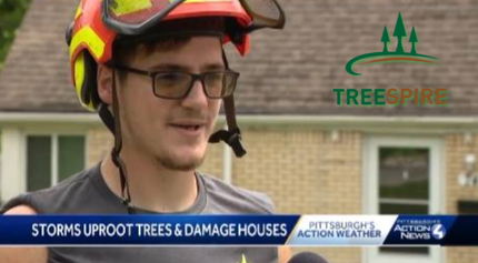 Man in safety helmet and glasses being interviewed in front of a house, with