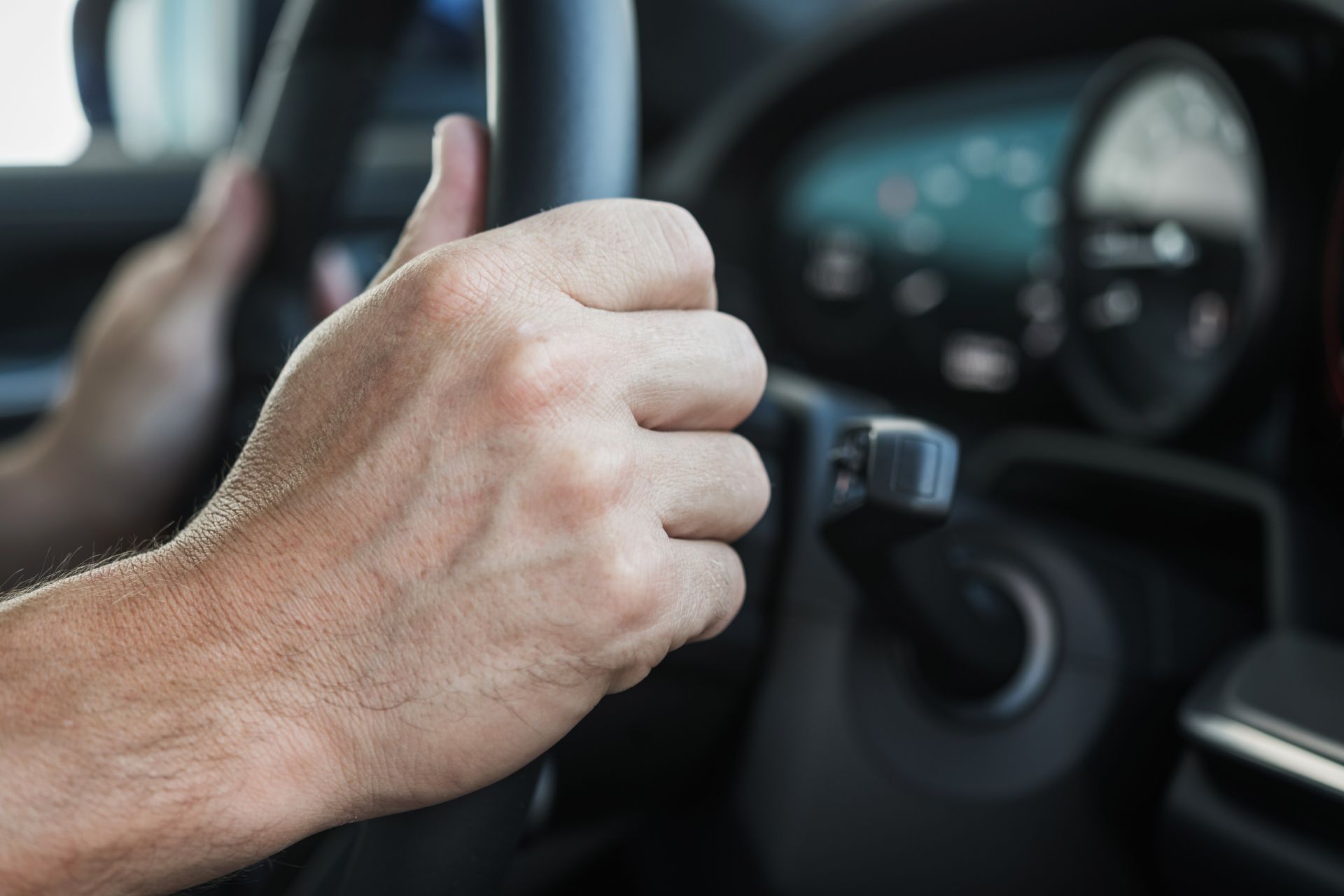 A man is giving a thumbs up while driving a car.