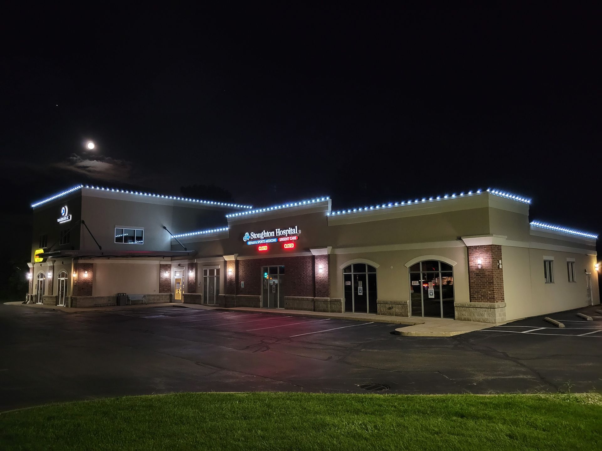 Nighttime exterior of a lit restaurant with red neon signs and a parking lot