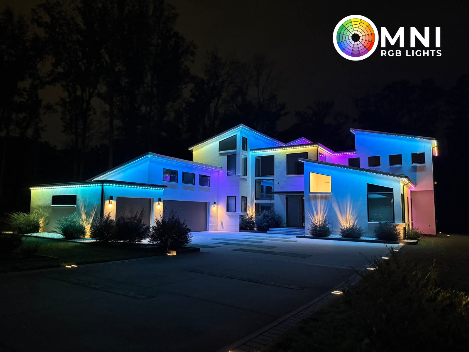 Modern house lit with colorful RGB lights at night, with OMNI RGB Lights logo in the corner