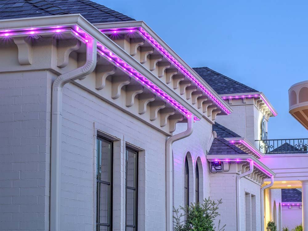 White building with pink-purple LED roof lights at dusk