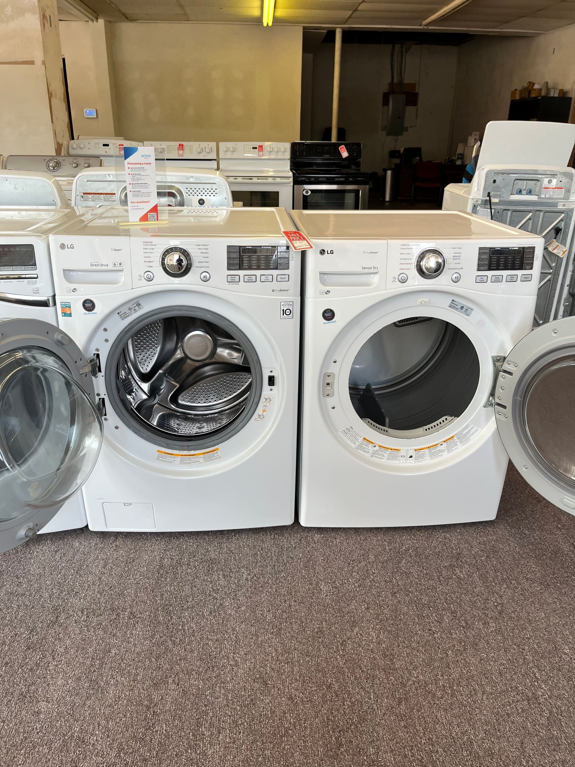 Beige top-load washing machine with open lid and control panel in a laundry area