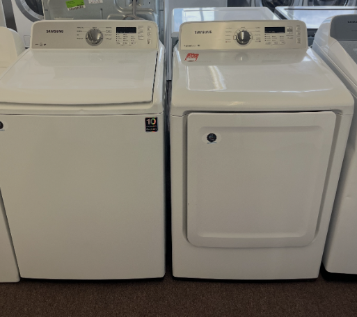 Two white laundry machines side by side in a laundromat, one with a front door and one with a top lid.