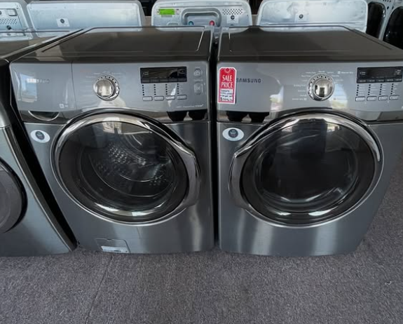 Two stainless steel front-load washing machines in a laundry store display row.