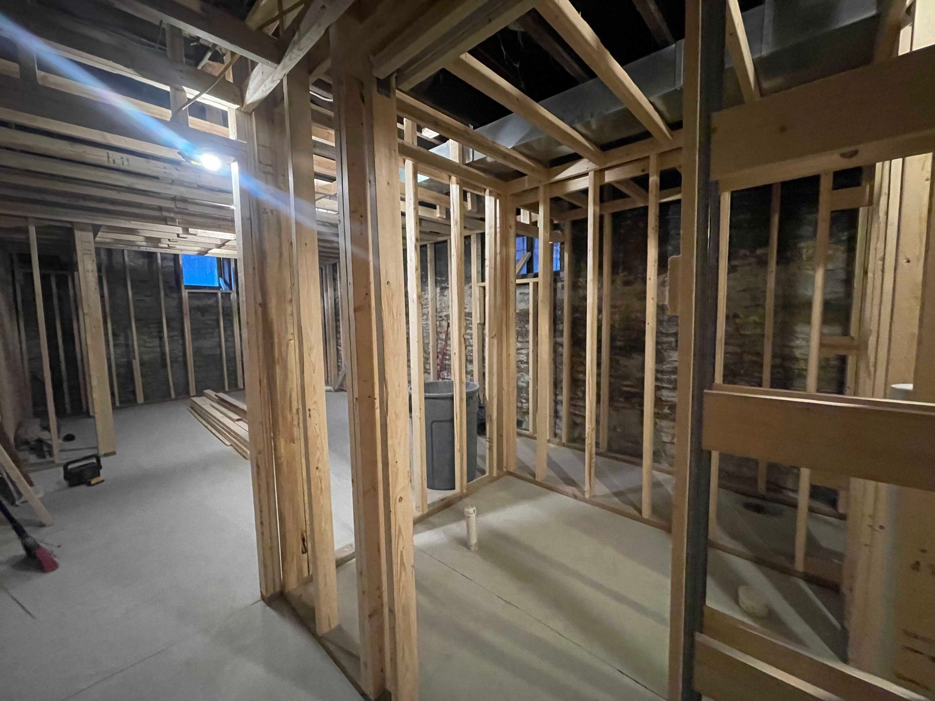 Basement under construction; wooden framing defines rooms on a concrete floor.