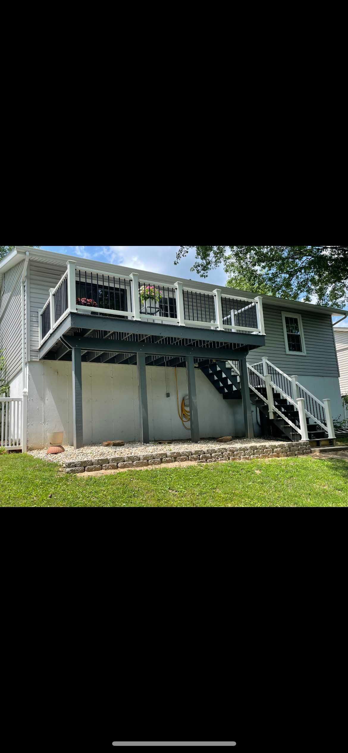House with two-tiered deck, gray siding, white trim, and a grassy yard.