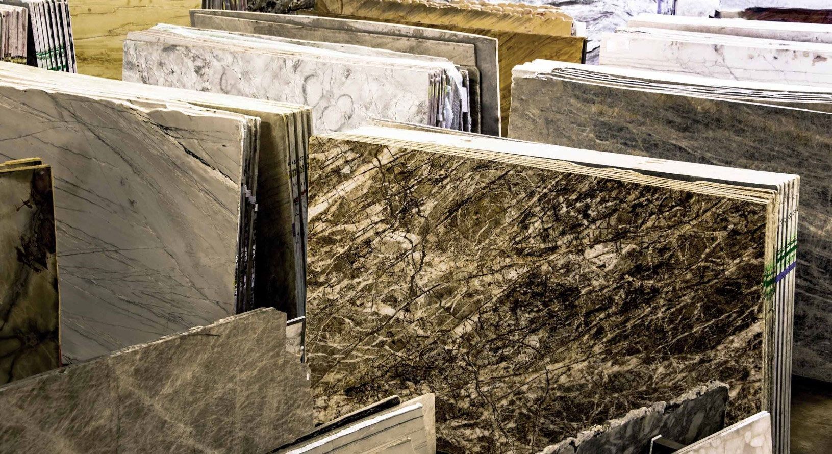 A bunch of marble slabs are stacked on top of each other in a warehouse