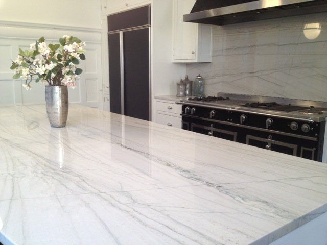 a kitchen counter with a vase of flowers on it