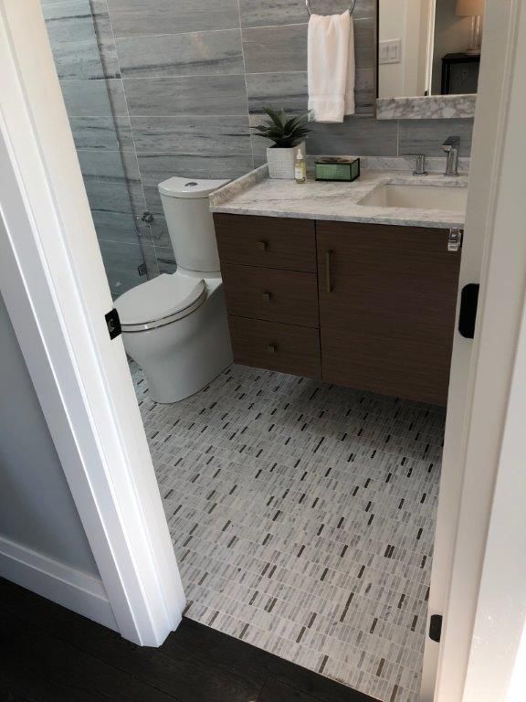 a bathroom with a toilet, sink and mirror