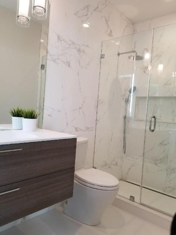 a bathroom with a toilet, sink and shower