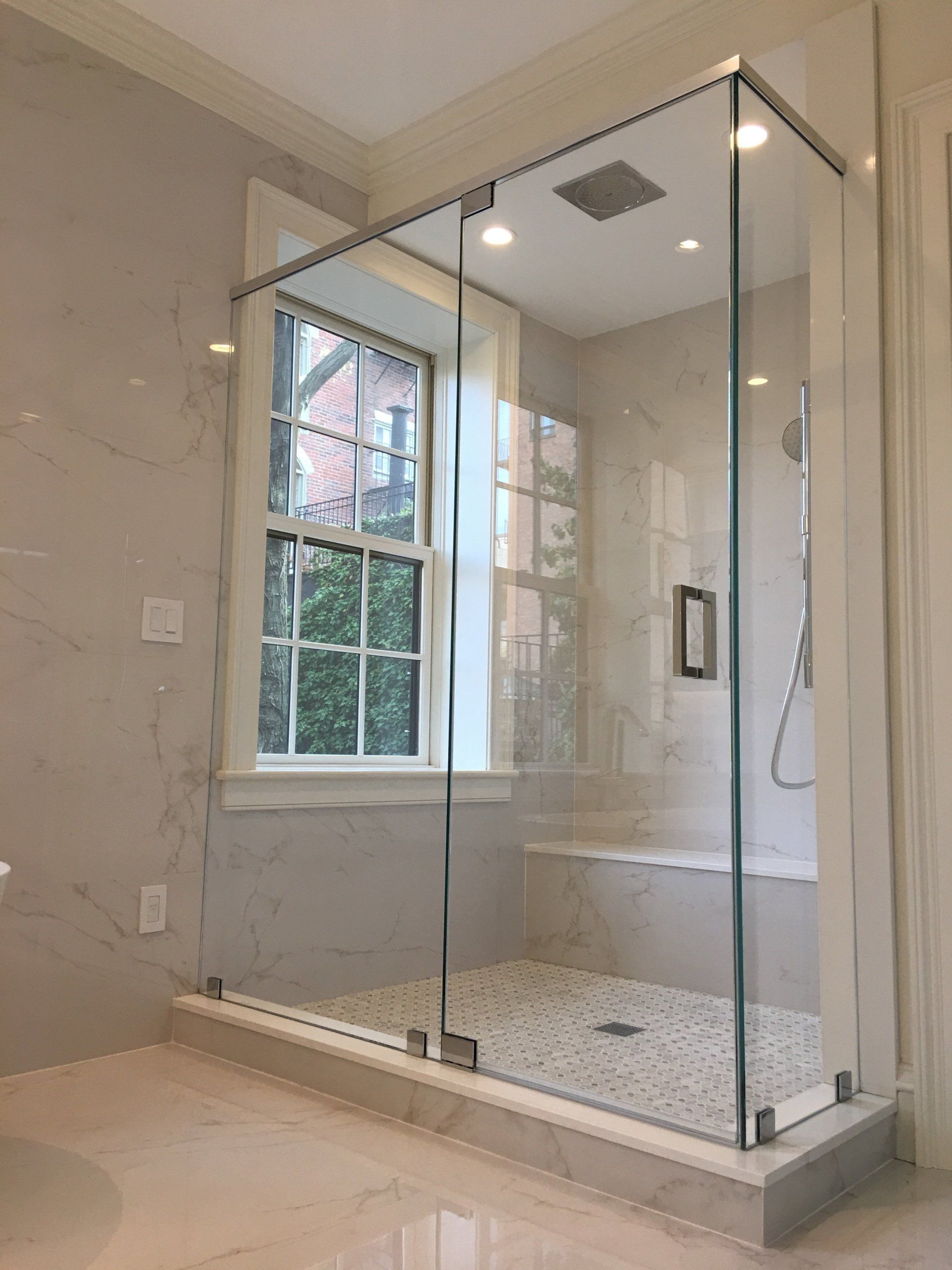a bathroom with a walk in shower and a window