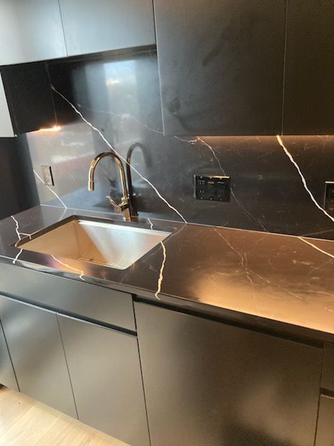 A kitchen counter with a sink and a faucet