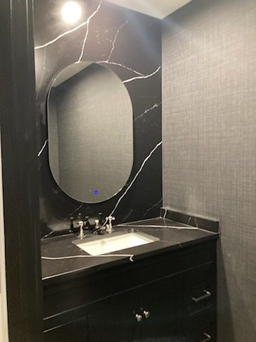 A bathroom with a sink, mirror, and vanity.