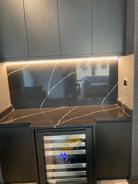 A kitchen with a wine cooler and a counter top.