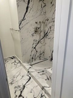 A bathroom with a black and white marble shower.