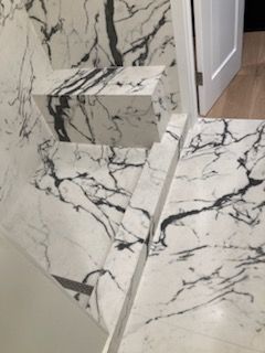 A bathroom with a black and white marble floor and stairs