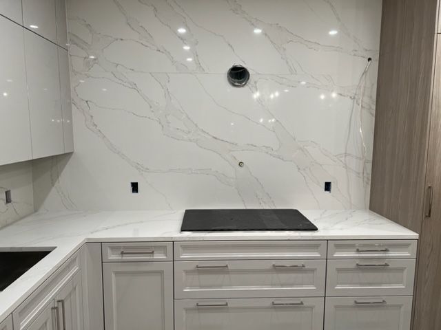 a kitchen with white cabinets and a black stove top oven