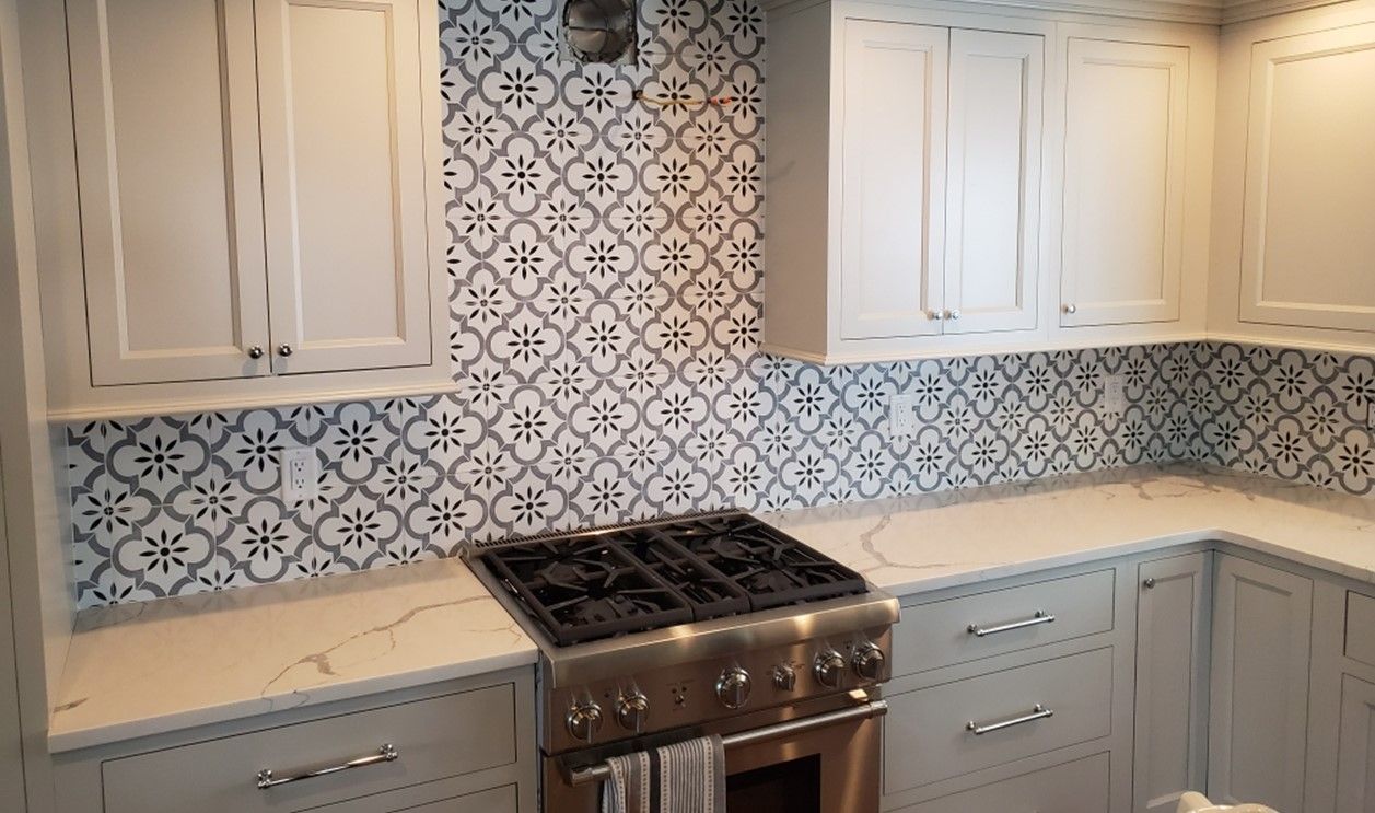 a kitchen with white cabinets, stainless steel appliances, and a stove top oven