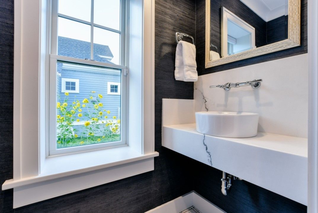 a bathroom with a sink, mirror and window