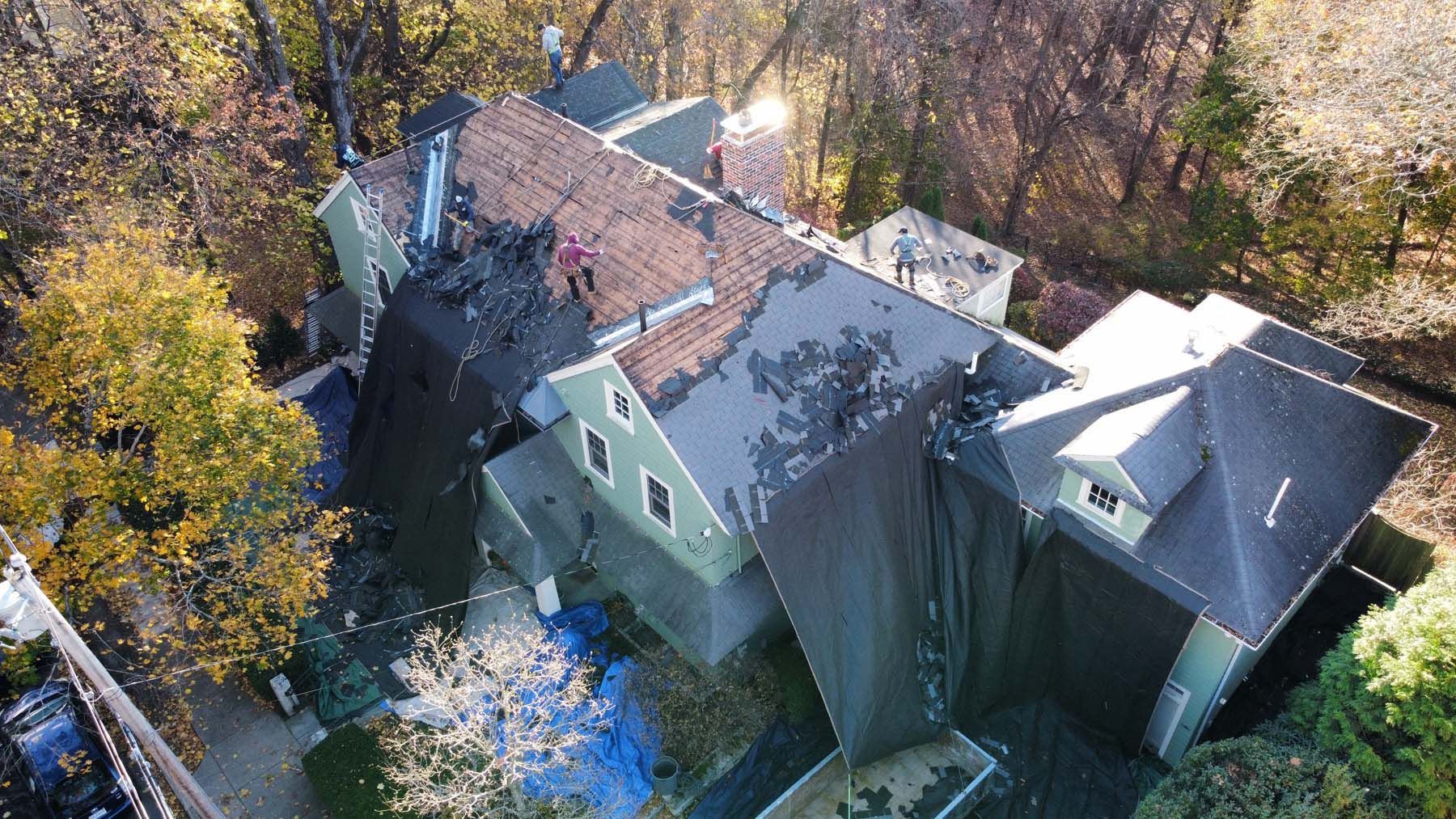 An aerial view of a large house with a roof that is being repaired.