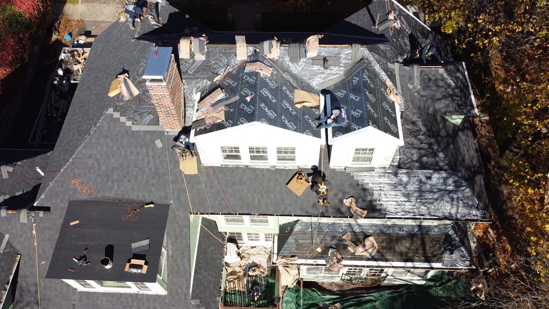 An aerial view of a house with a roof that is being repaired.