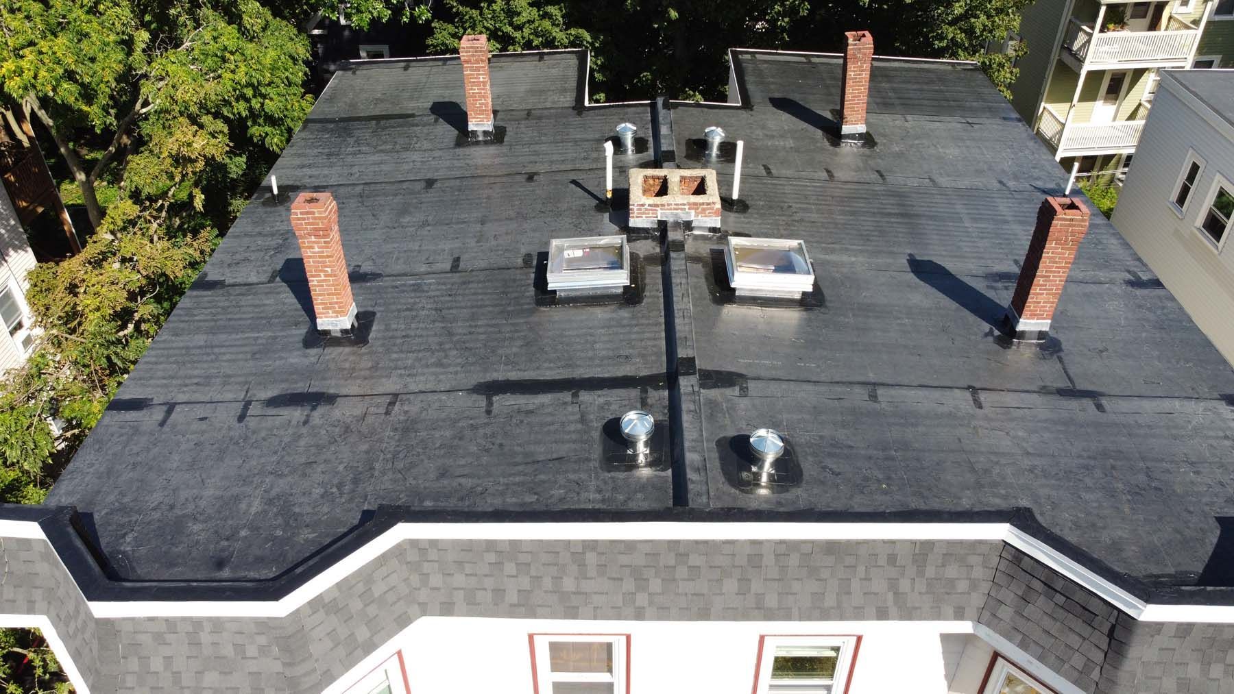An aerial view of a roof of a building with chimneys.