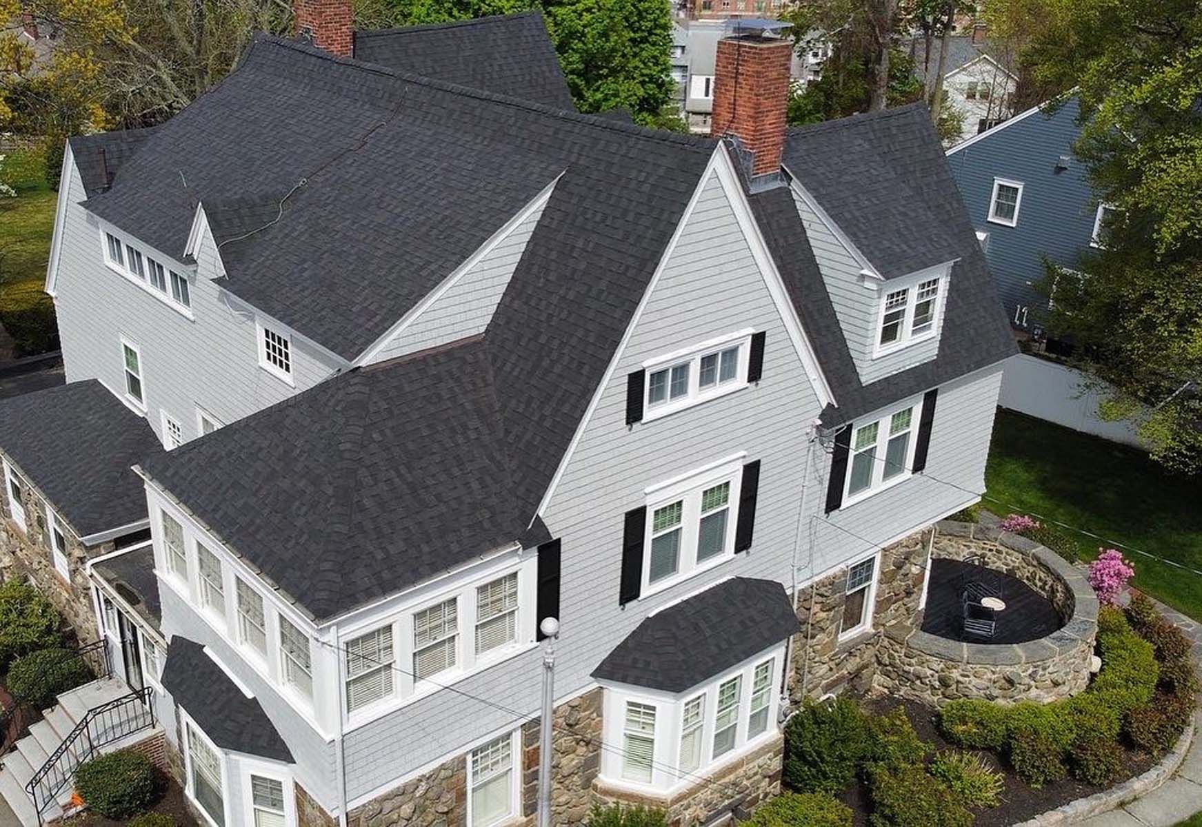 An aerial view of a large house with a black roof.