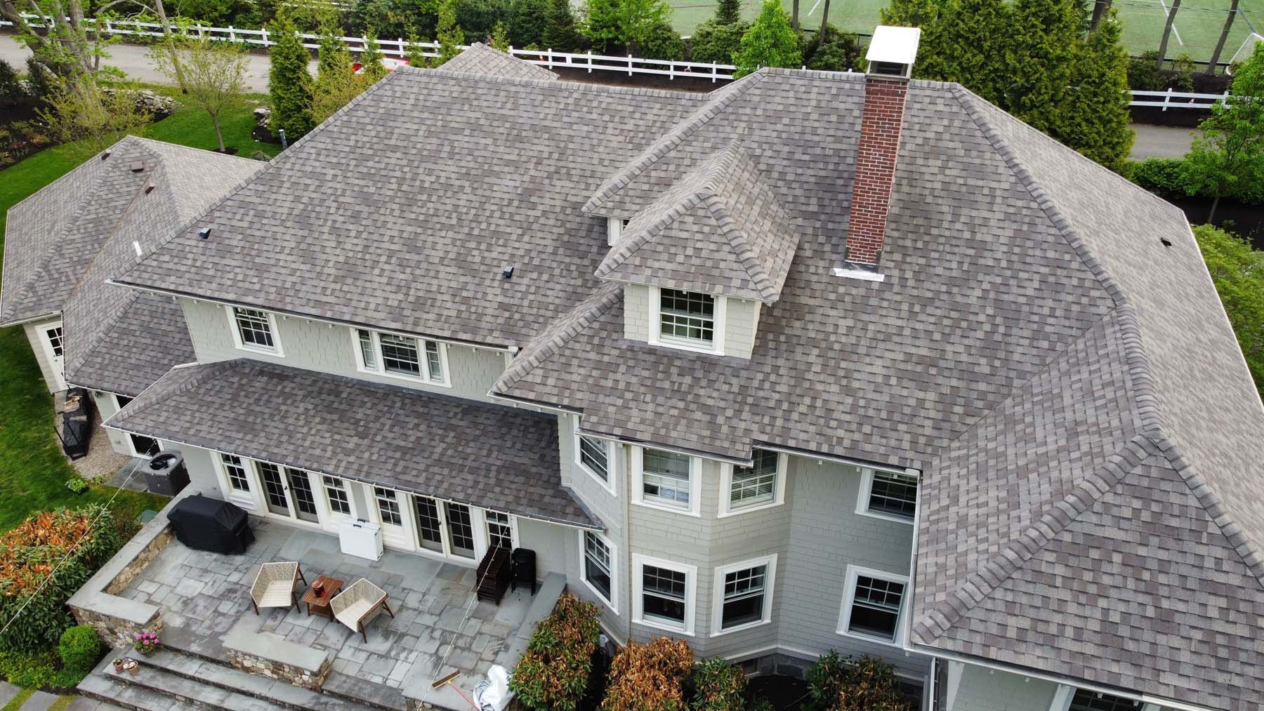An aerial view of a large house with a gray roof.
