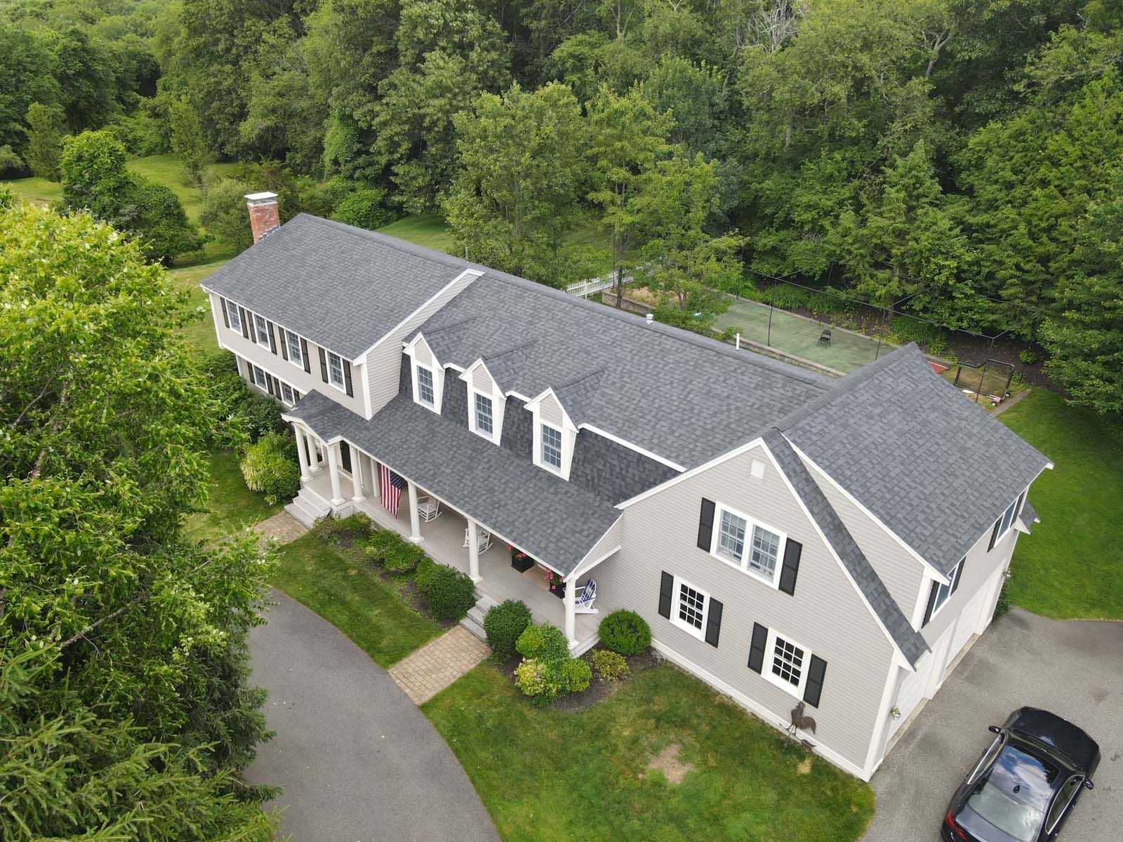 An aerial view of a large house with a car parked in front of it.