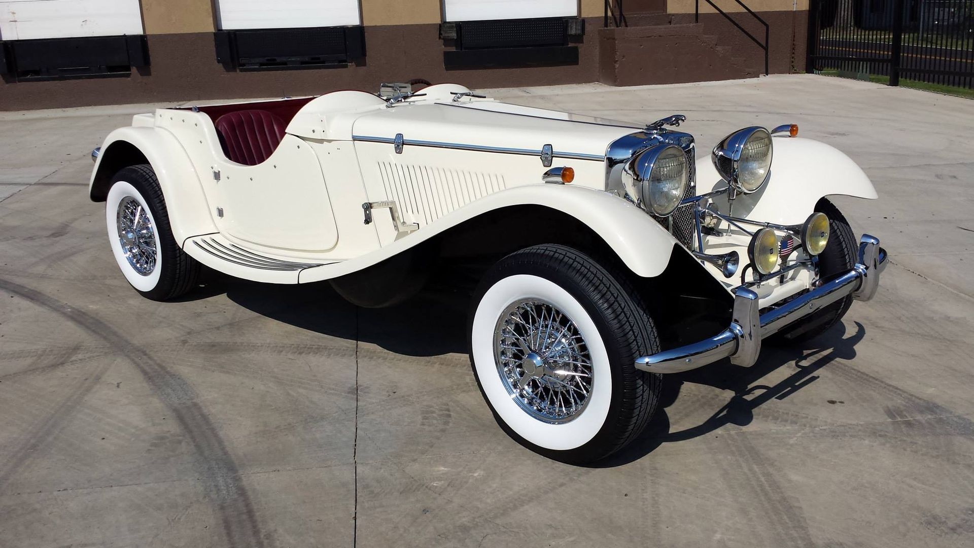 A white car with white tires is parked in a parking lot.