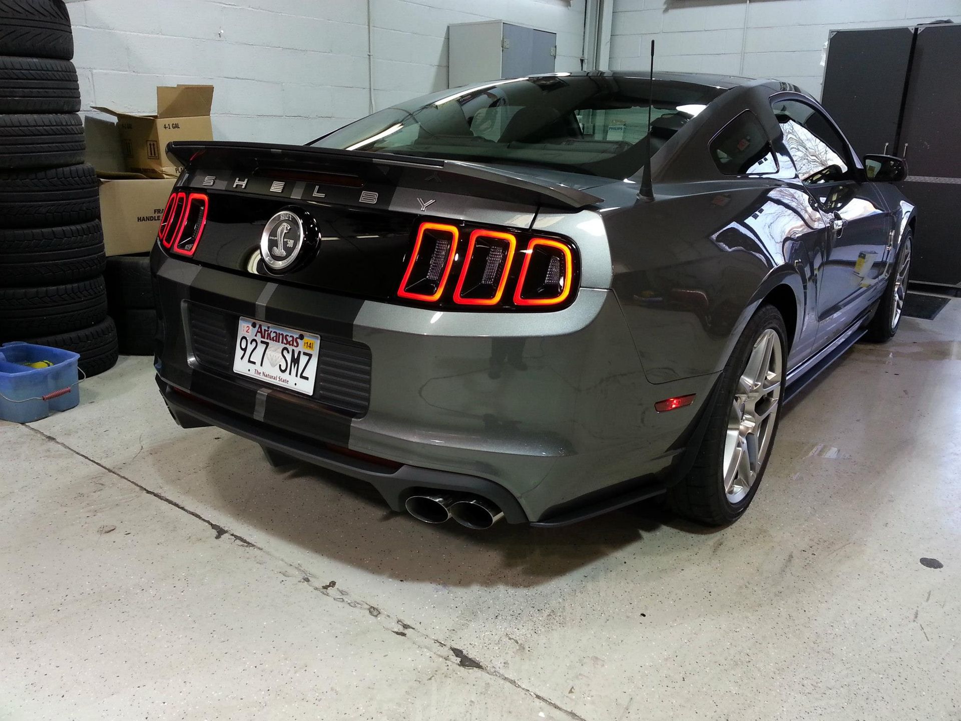 A gray ford mustang is parked in a garage.