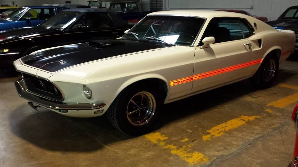 A black and white mustang is parked in a garage.