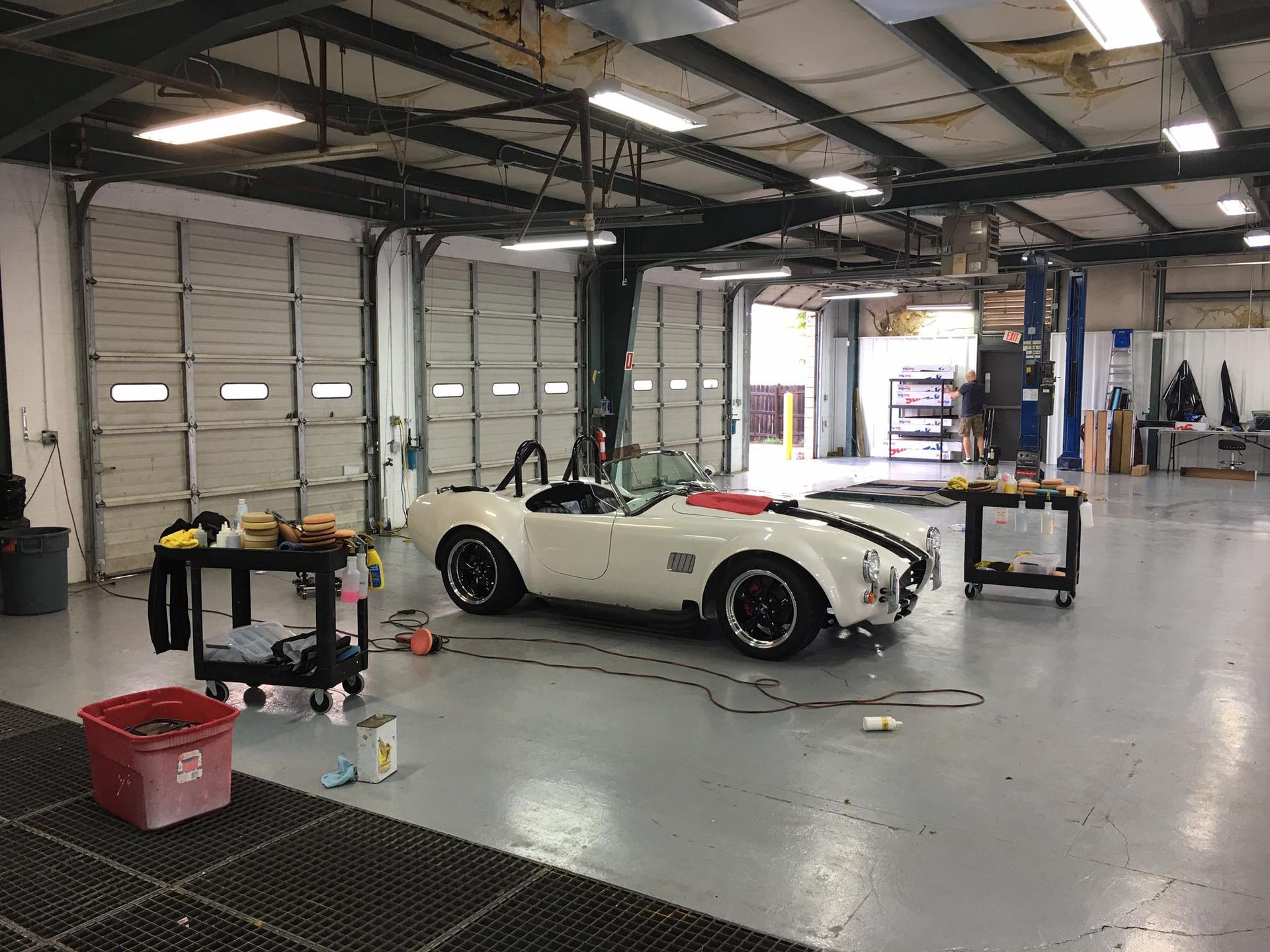 A white sports car is parked in a garage.