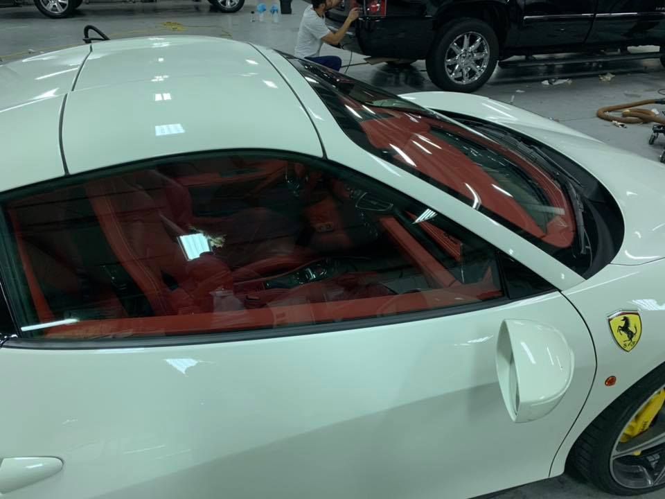 A white ferrari sports car is parked in a garage.