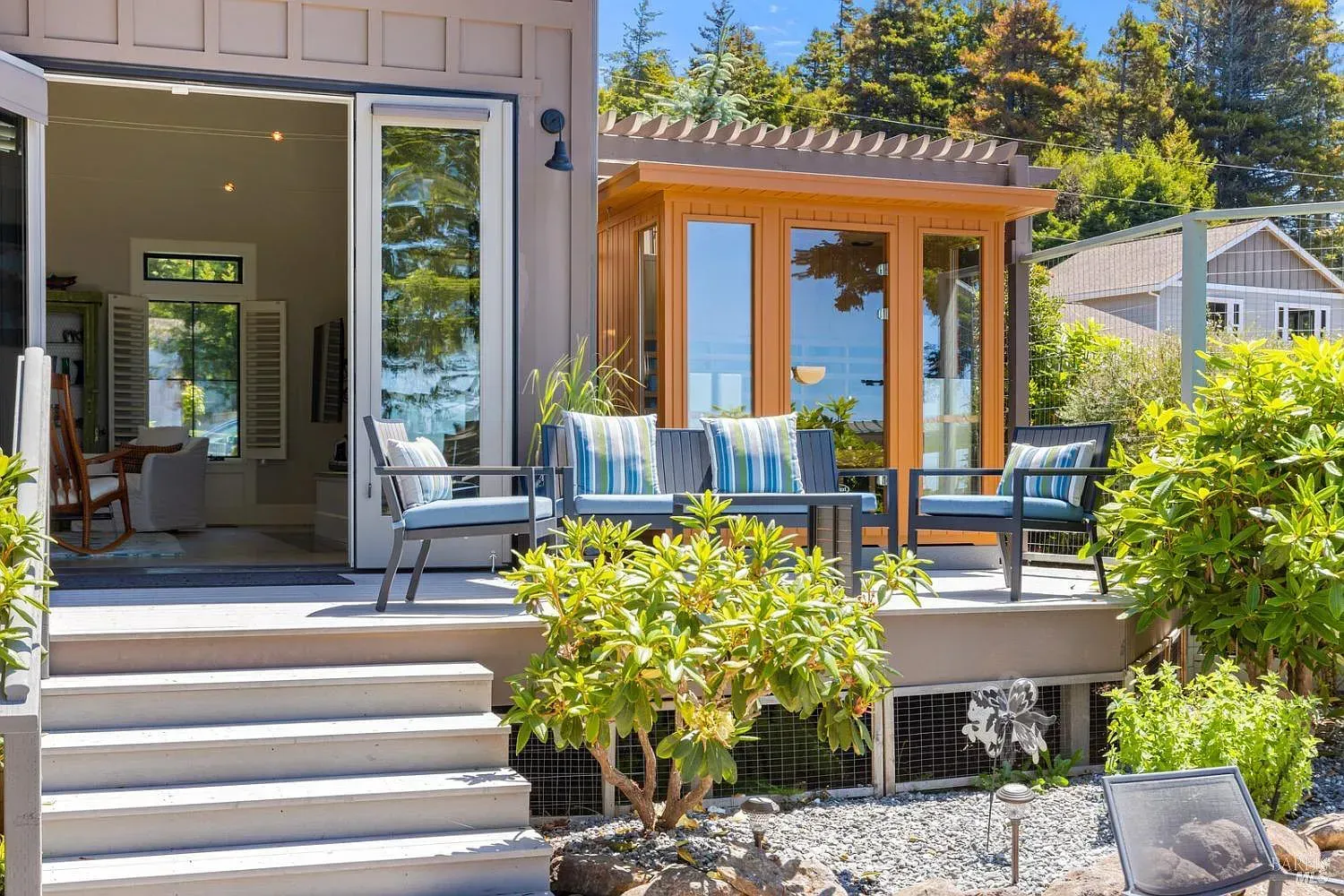 a small house with a deck and stairs leading to it