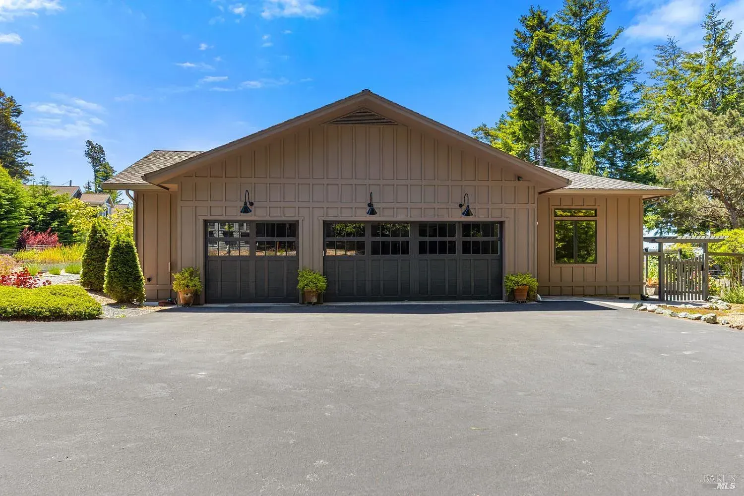 a large brown house with a black garage door