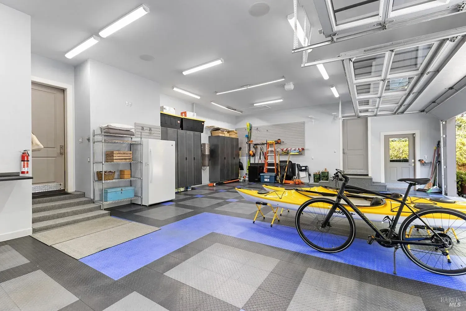 a bicycle is parked in a garage next to a kayak
