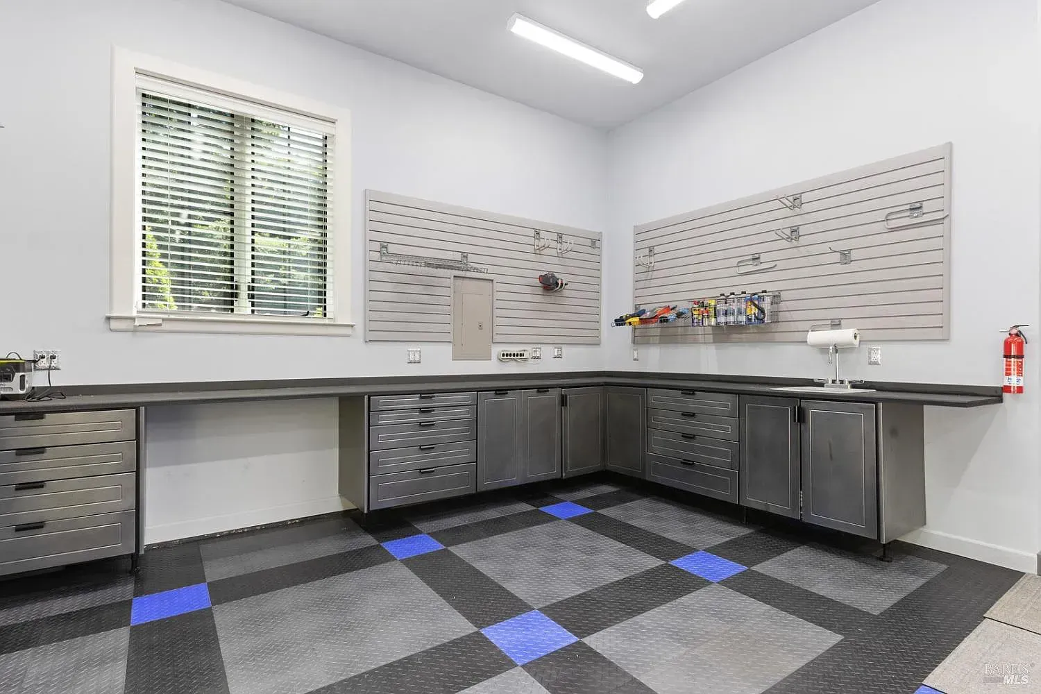a garage with stainless steel cabinets and a checkered floor