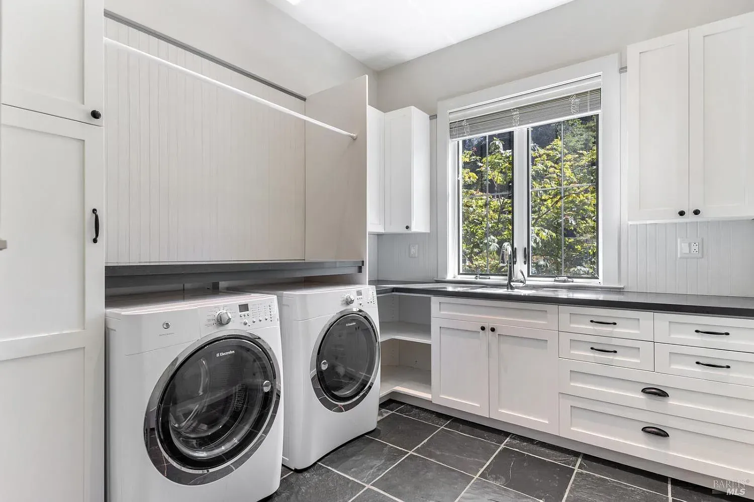 a laundry room with a washer and dryer and a sink